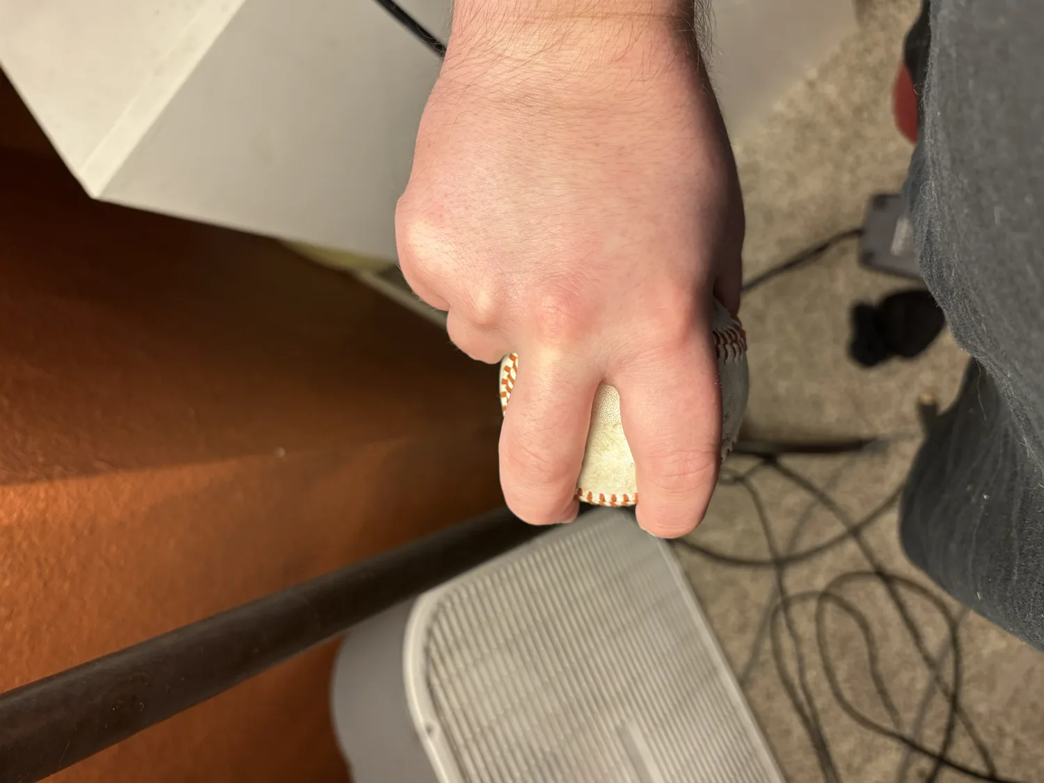 The underside of a four-seam grip, the thumb supporting the ball centered below the two top fingers.