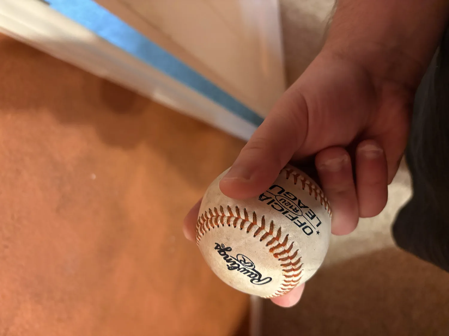 A side view of a split-finger fastball grip, the fingers straddling the seams.