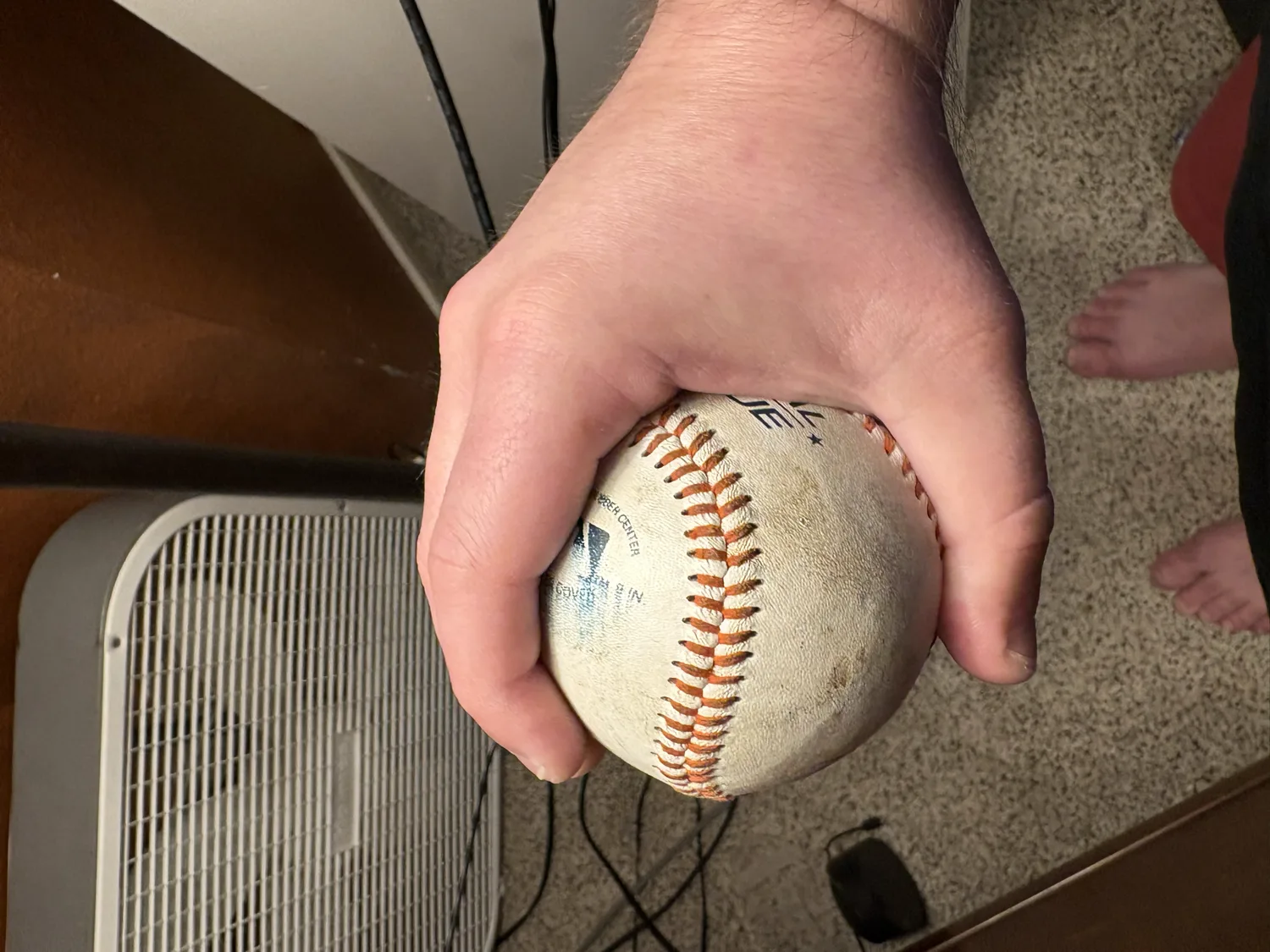 A side view of a 12-6 curveball grip, two fingers against the seam with the thumb under the ball.