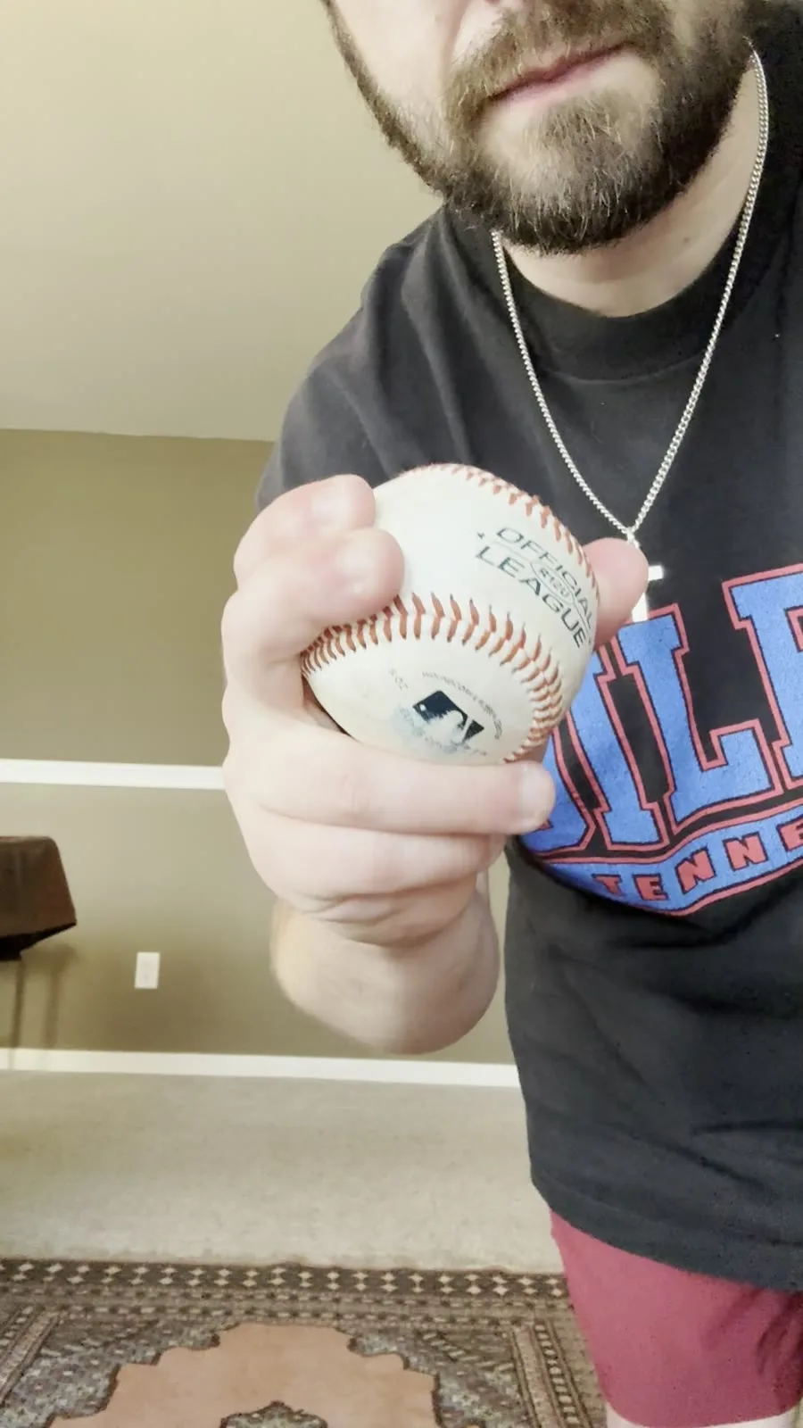 A looping close-up of Austin's 12-6 curveball grip: two fingers tucked together and cornered against one seam.