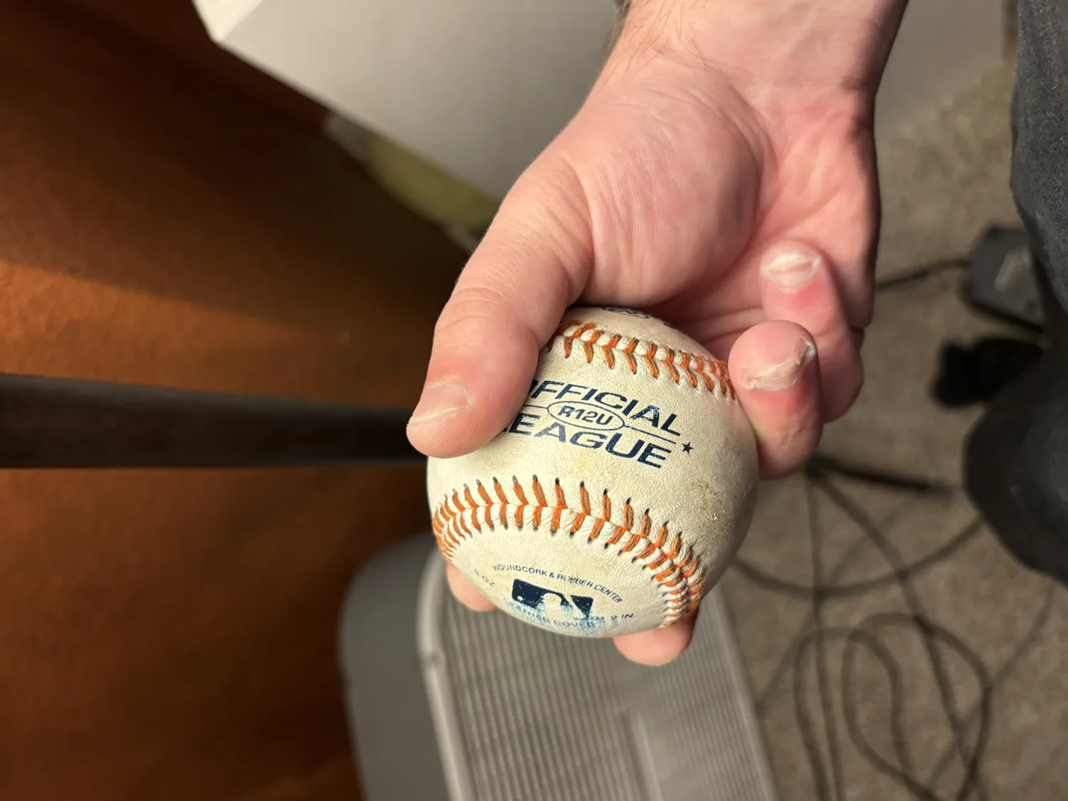 A two-seam fastball grip viewed from the front, fingers resting on the parallel seams.